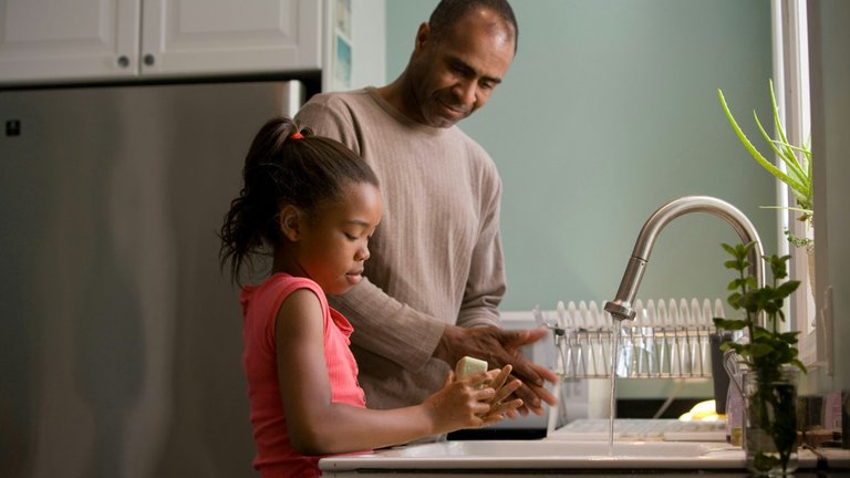 father and daughter washing dishes together
