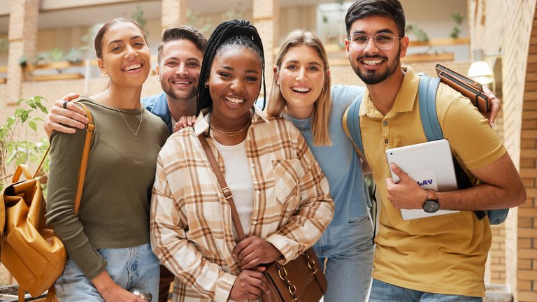 A diverse group of smiling young adults in arms
