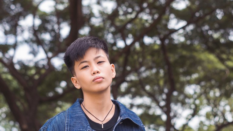 A teenager in a jean jacket with a serious gaze