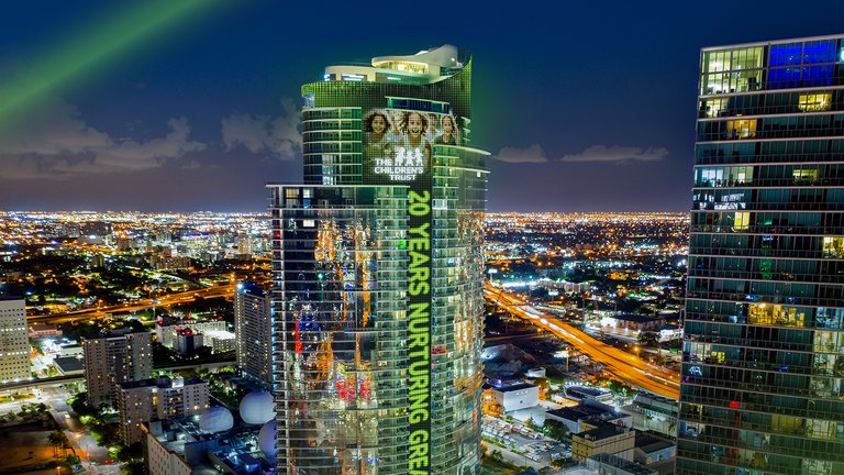 City building at night displaying '20 Years Nurturing Greatness.