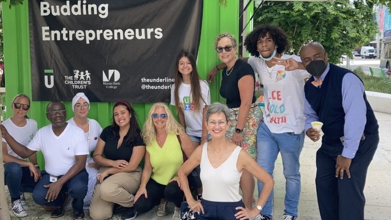Group posing in front of 'Budding Entrepreneurs' banner.