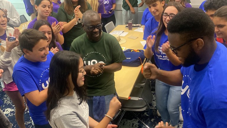 Group of people playing a game, smiling, and clapping.