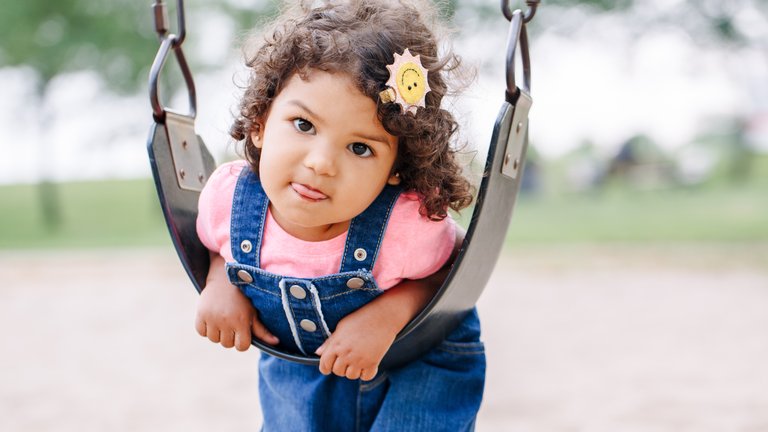 A small child playing on a swing