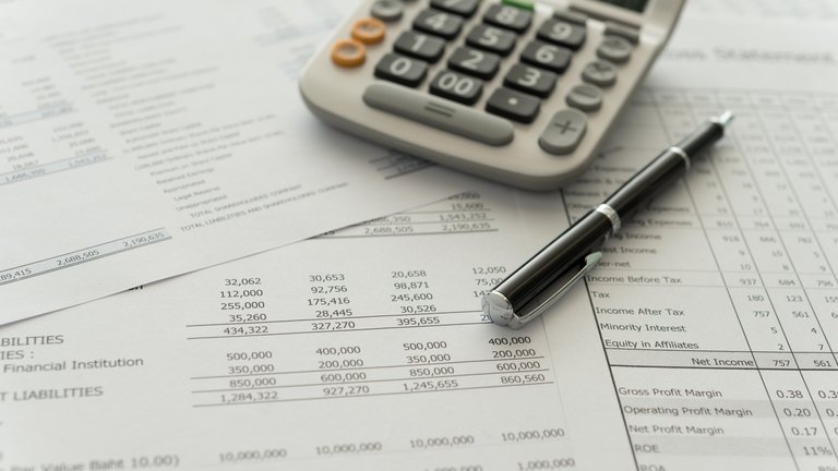 Close up photo financial documents, a calculator, and a pen.