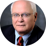 A man in a suit with glasses and a tie.