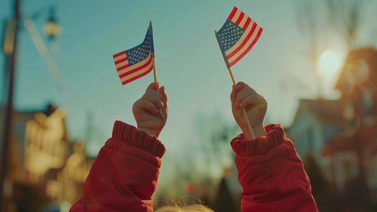 Young person holding two small sticks with USA flags high in the air