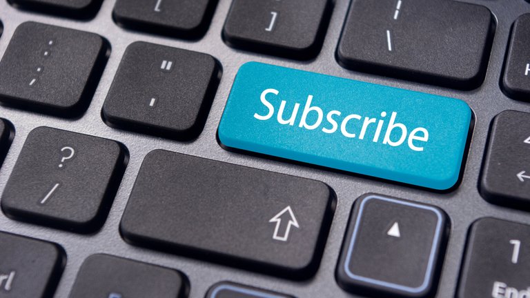 Close-up of a keyboard with a bright blue 'Subscribe' key.