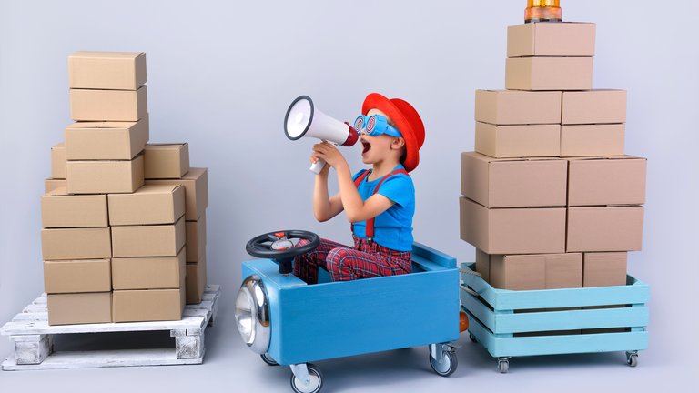 little boy in a toy car with a megaphone